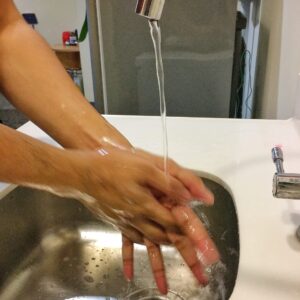 person washing hand on sink